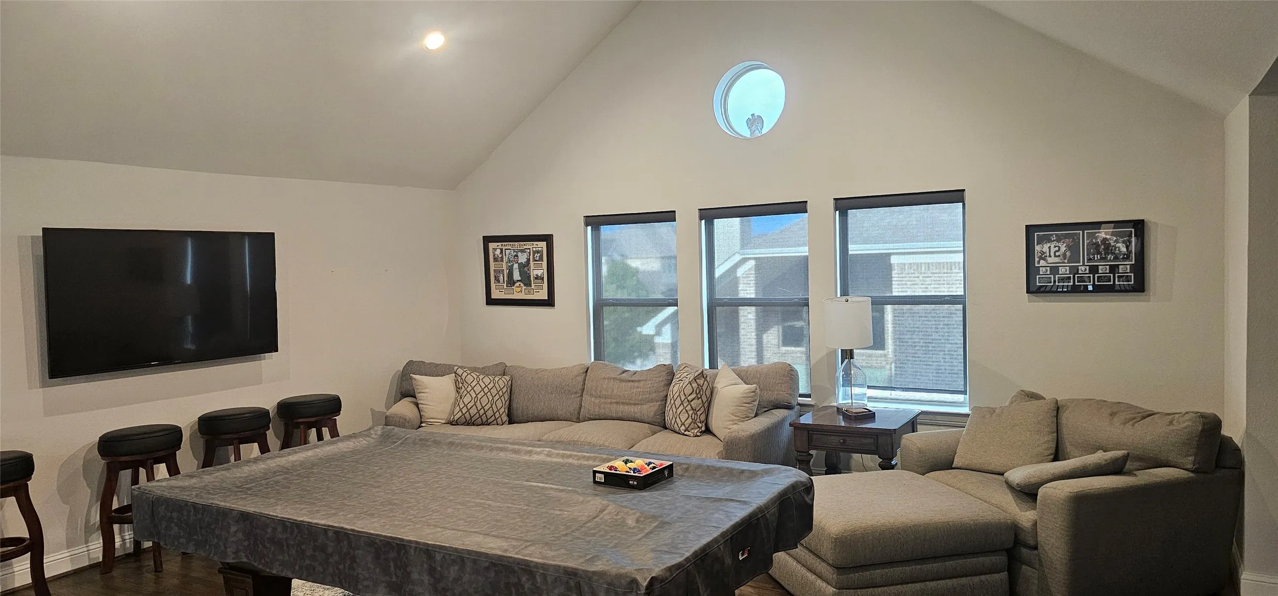 Vaulted ceiling, recessed lighting, circular accent window, three tall windows, wood-finish flooring