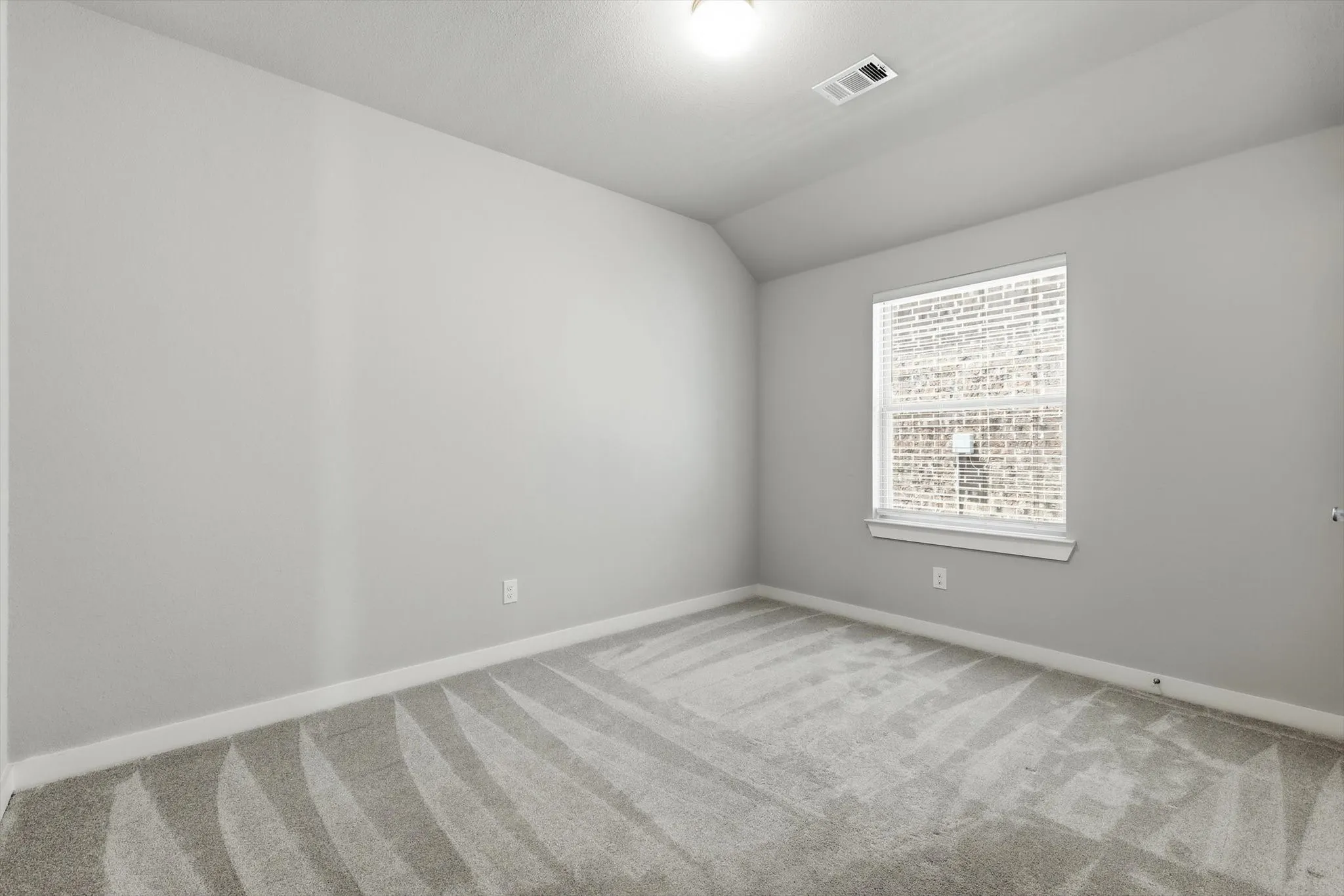 Bright secondary bedroom with walk in closet, recessed ceiling lighting and split bathroom.