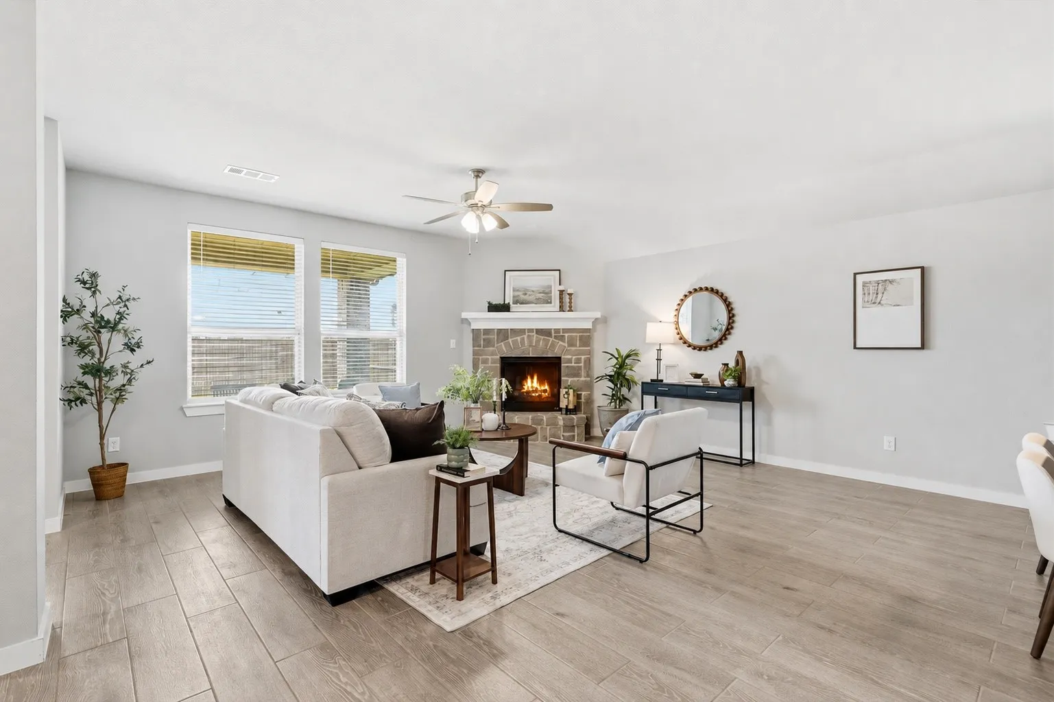 WOW! The natural lighting in this room is breathtaking. An open concept living area featuring wood look plank tile, gas fireplace with brick/stone surrounding, flat screen wiring with two dining spaces, or additional sitting etc with views of the kitchen