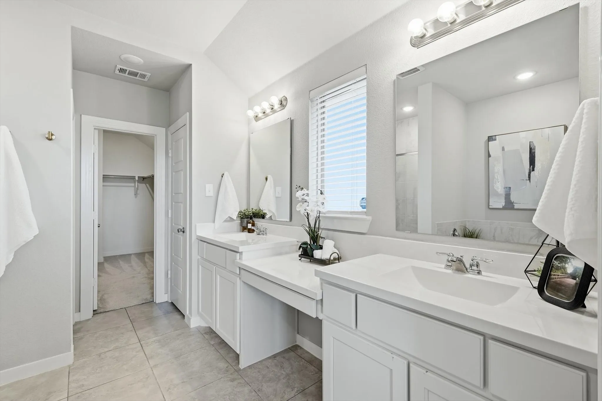 Large ensuite primary bathroom with dual vanities, make up or sitting space, separate shower and soaking tub with massive walk in closet.