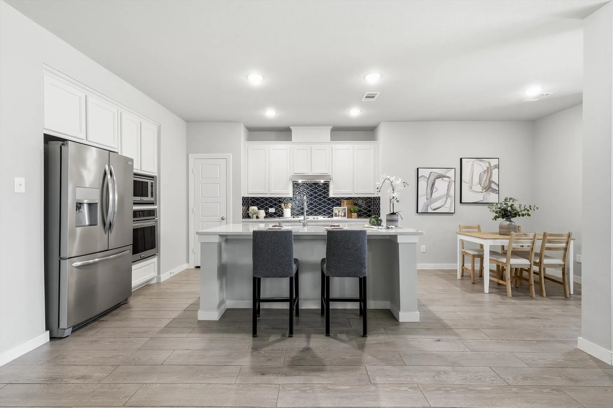 Open-concept kitchen with stylish backsplash, ss appliances. gas cooktop, large island, plenty of storage and bright lighting!