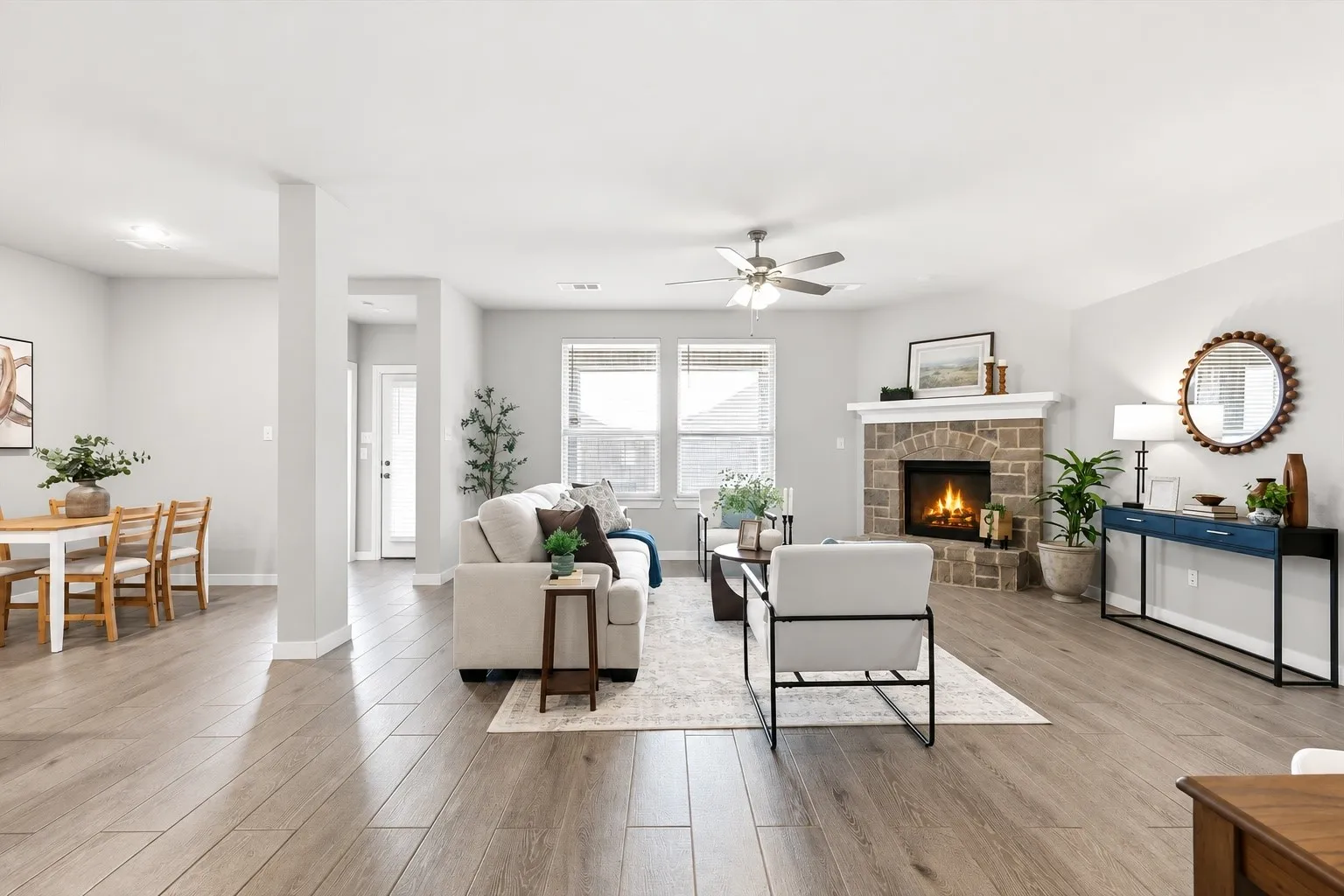 WOW! The natural lighting in this room is breathtaking. An open concept living area featuring wood look plank tile, gas fireplace with brick/stone surrounding, flat screen wiring with two dining spaces, or additional sitting etc with views of the kitchen