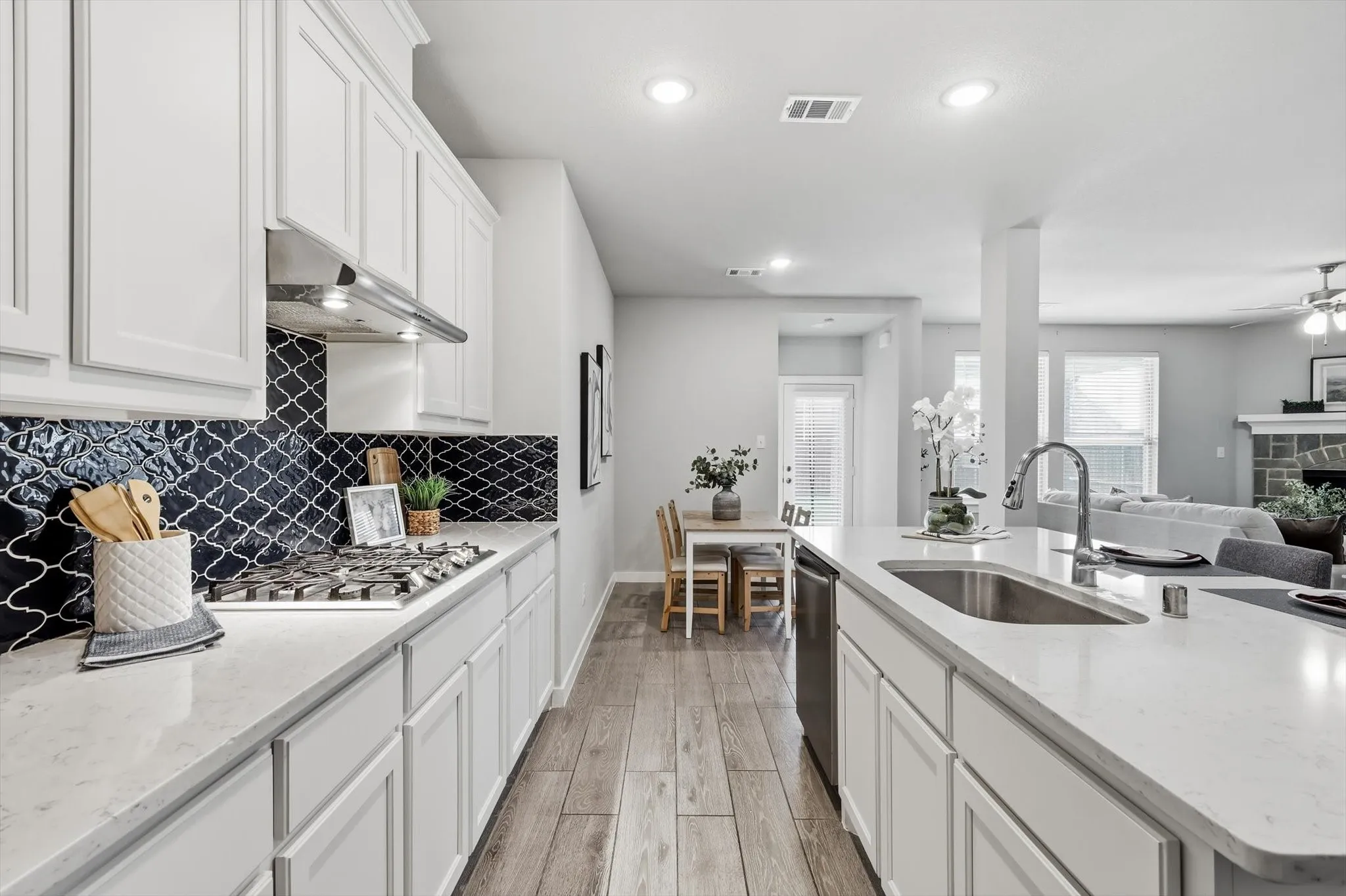 Open-concept kitchen with stylish backsplash, ss appliances. gas cooktop, large island, plenty of storage and bright lighting!