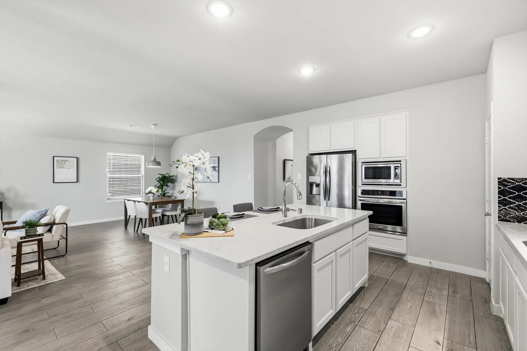 Open-concept kitchen with stylish backsplash, ss appliances. gas cooktop, large island, plenty of storage and bright lighting!