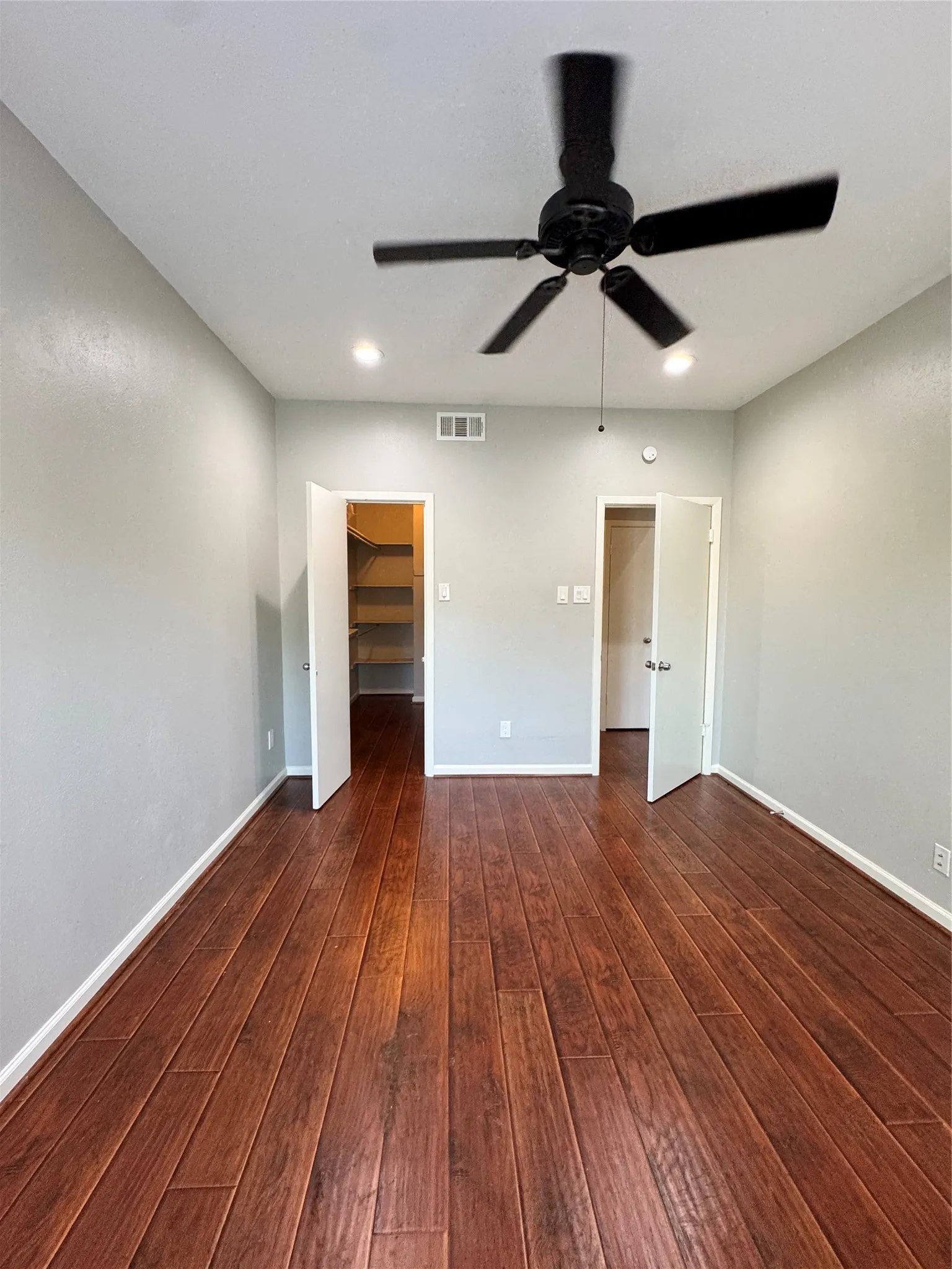 Wood-finish flooring throughout, with a ceiling fan and recessed lighting