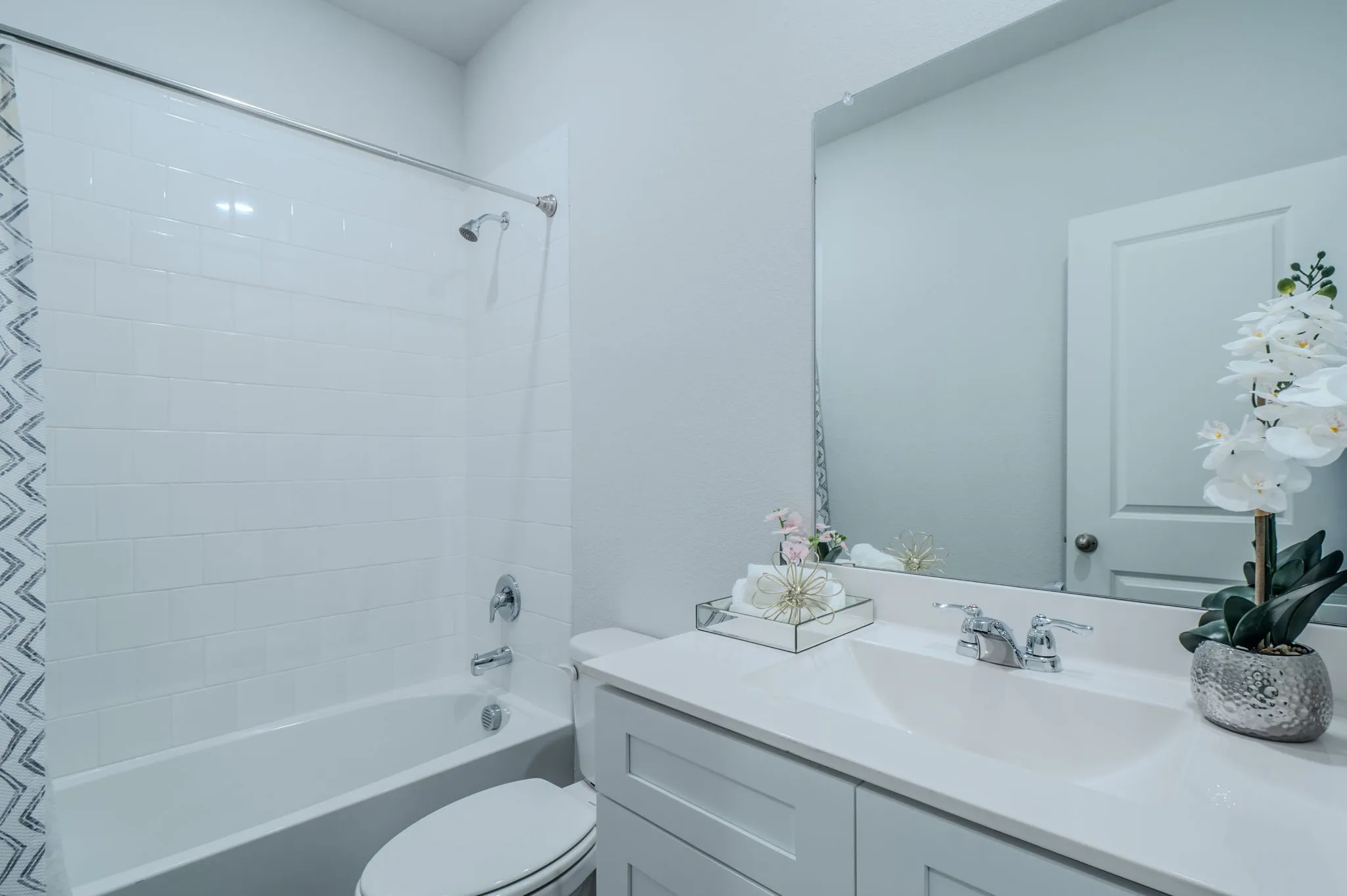 Bathroom featuring a single vanity with light cabinetry, an integrated sink, and a chrome faucet