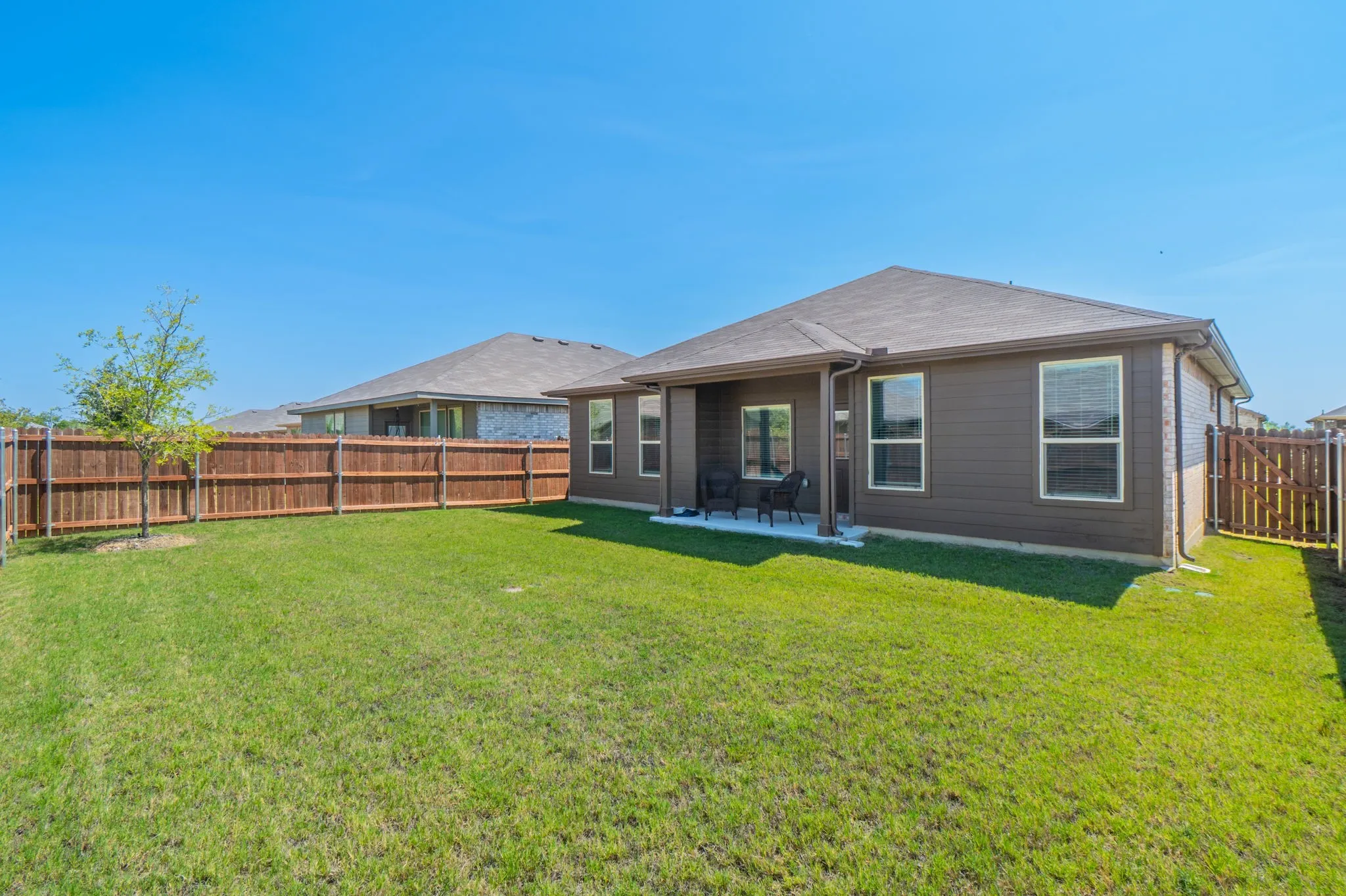 Expansive green lawn with a full privacy fence