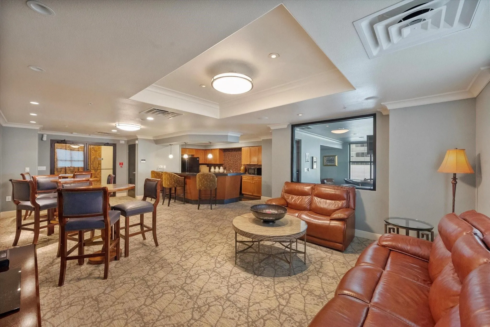 Open-concept common area featuring carpet flooring, recessed lighting, crown molding, and a built-in wet bar with pendant lighting
