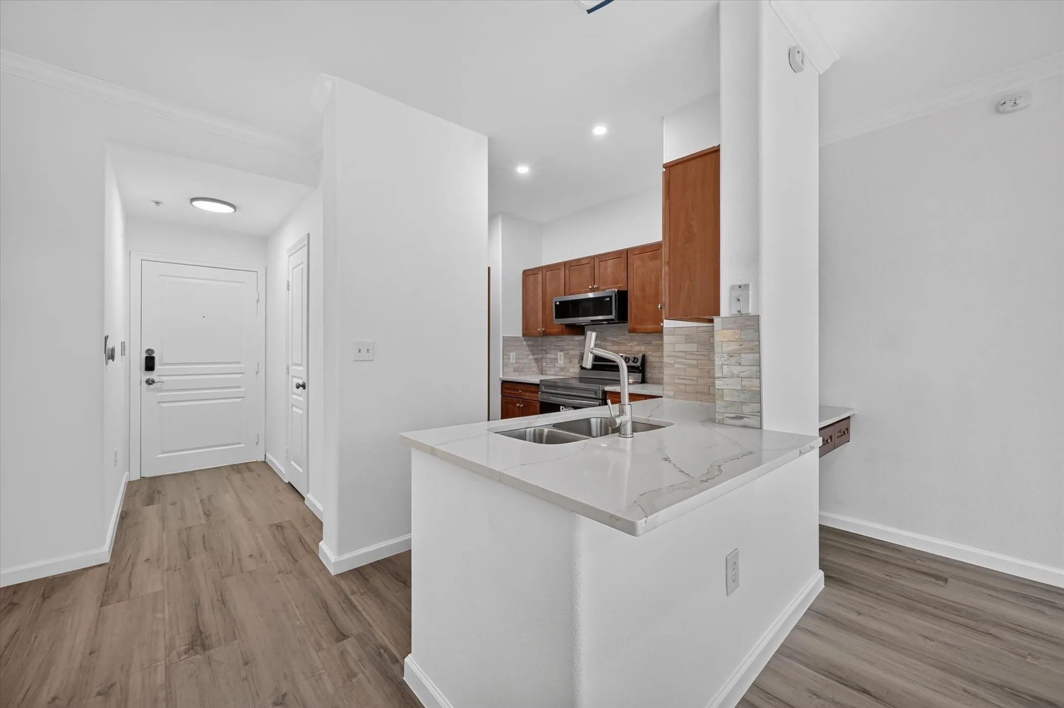 Kitchen area with wood-finish flooring and white walls