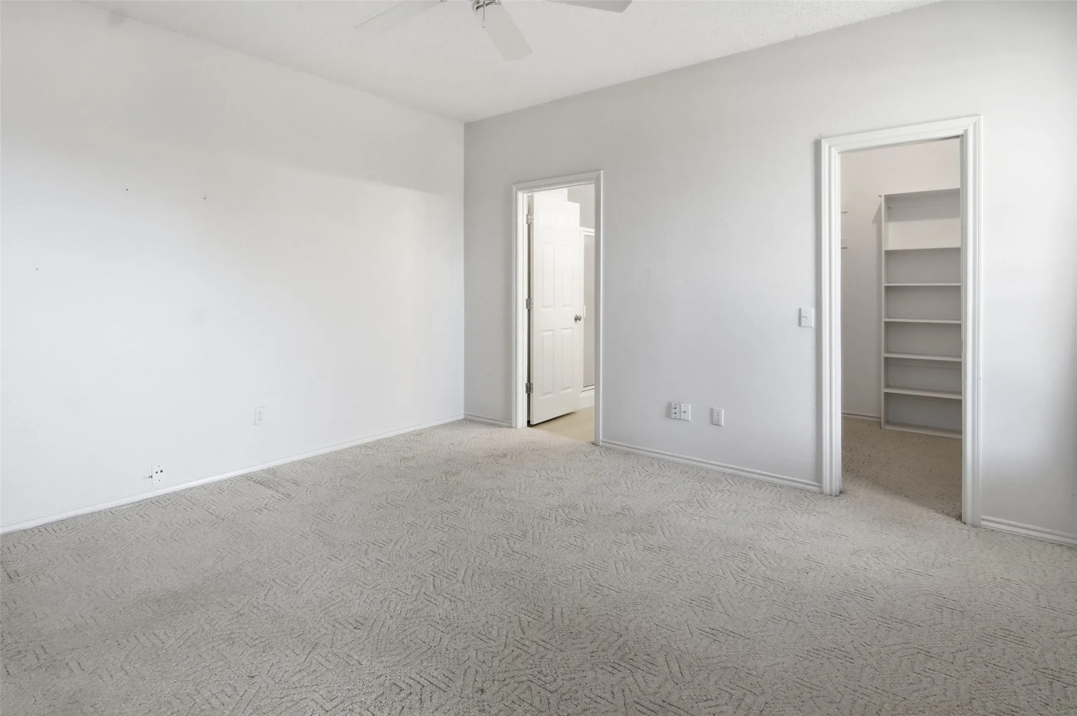 primary bedroom with  walk in closet and primary bathroom