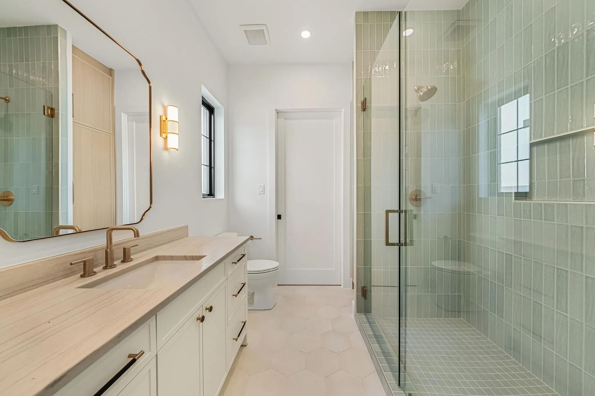 Bathroom featuring a glass-enclosed shower with vertical tile, a built-in shower bench, and a rectangular niche