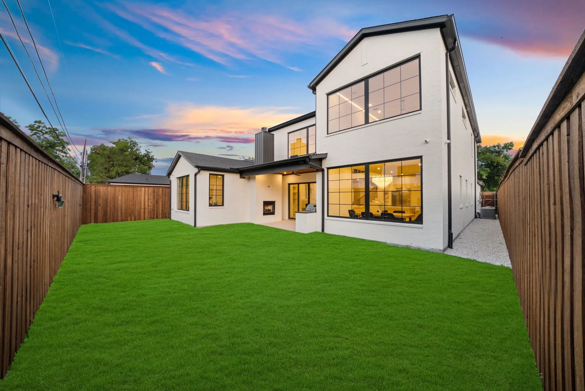 Modern residence featuring a stucco exterior, black-framed windows, and a black roofline