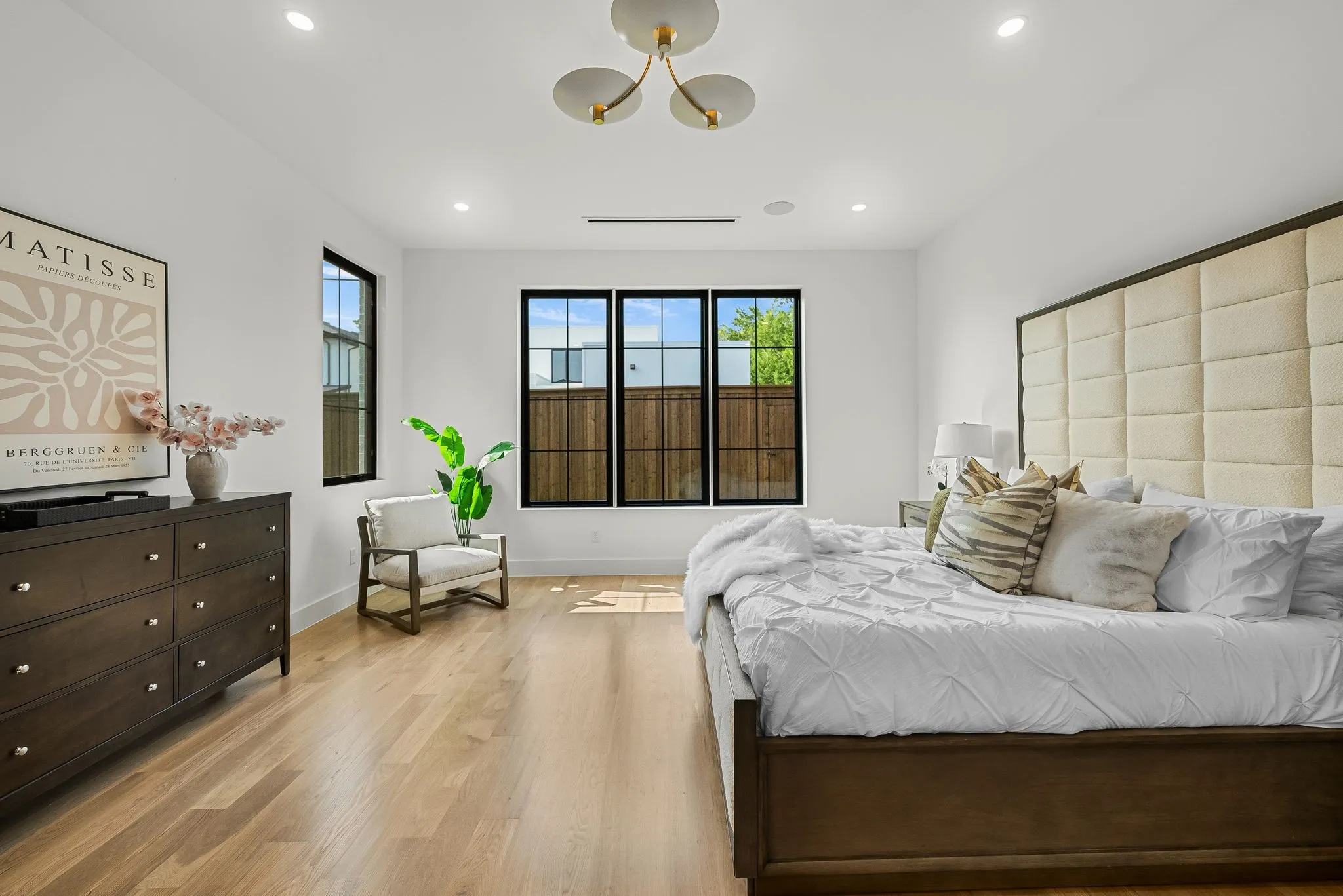 Spacious room featuring light wood-finish flooring, recessed lighting, and a modern ceiling fixture