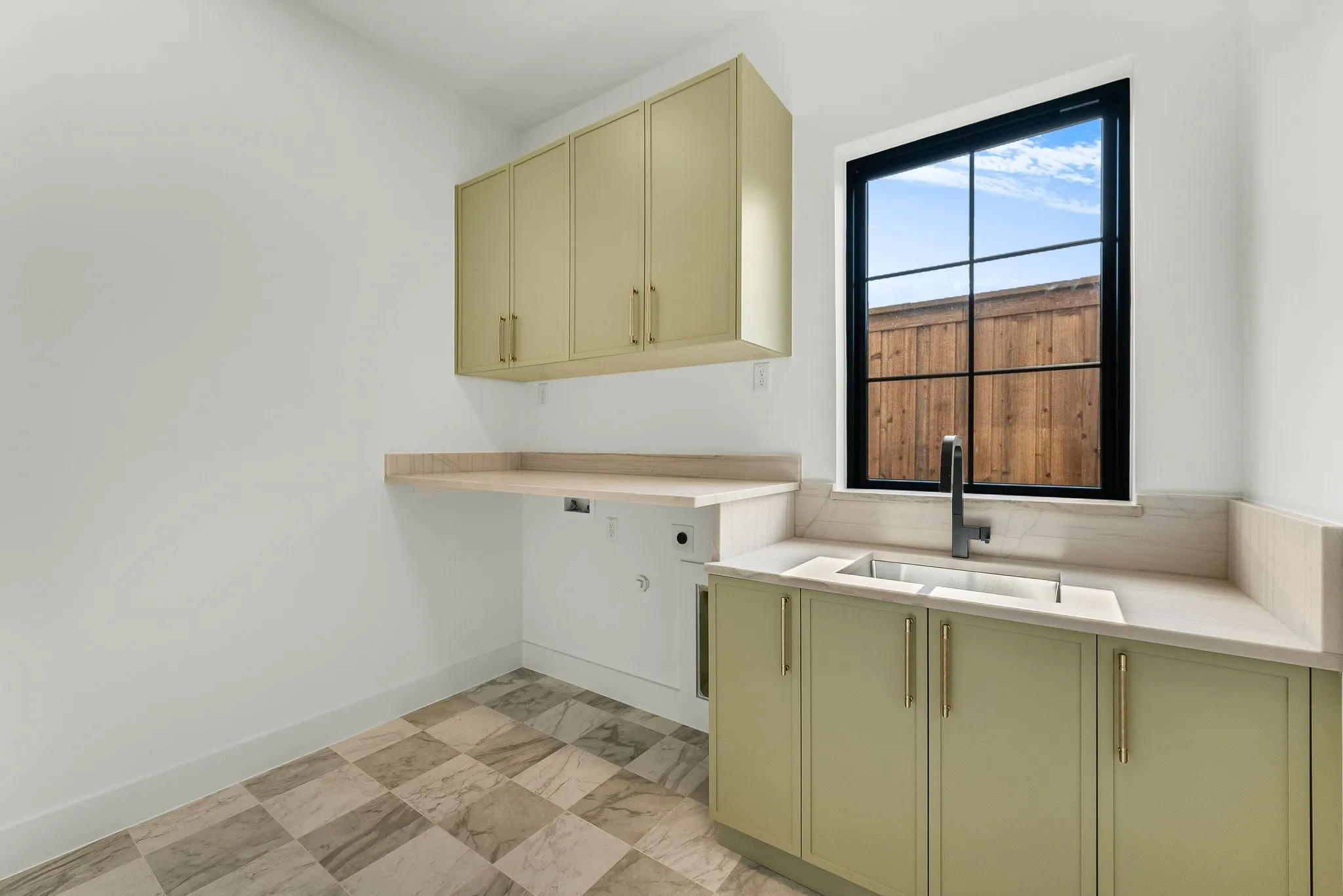 Utility room featuring ample cabinetry and a divided sink