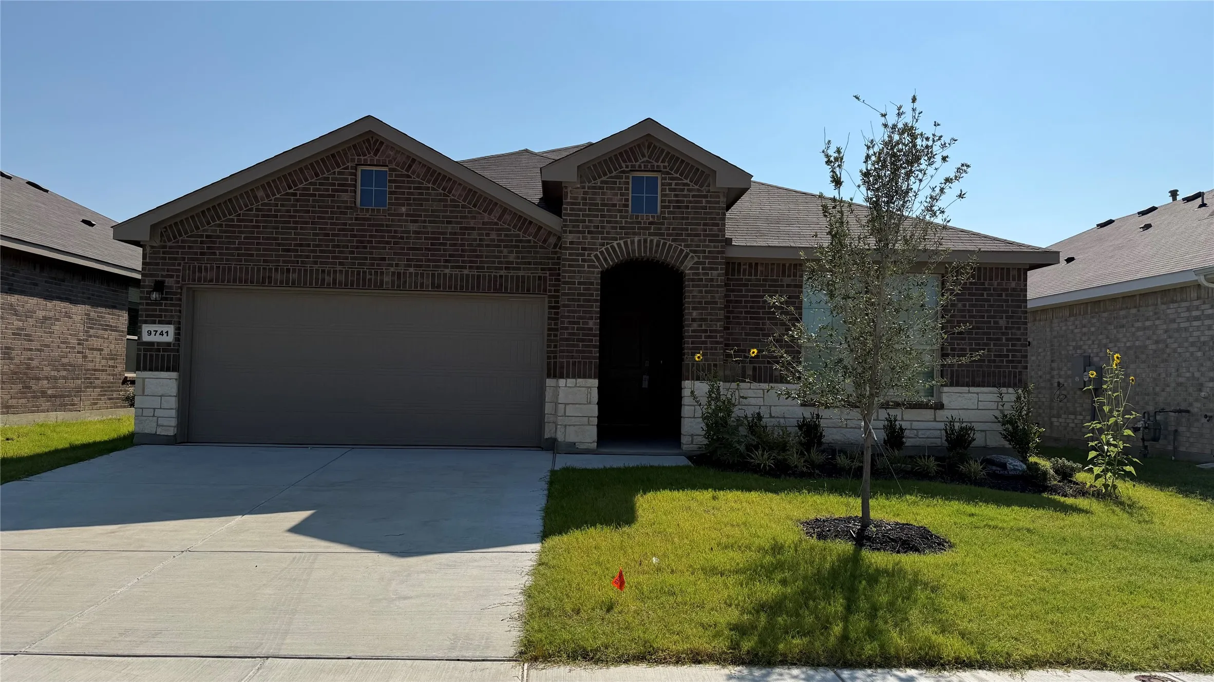 Brick and stone veneer exterior with an attached garage