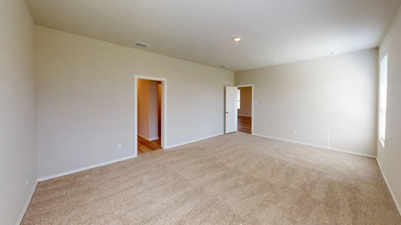 Spacious room featuring neutral carpeting and light-toned walls