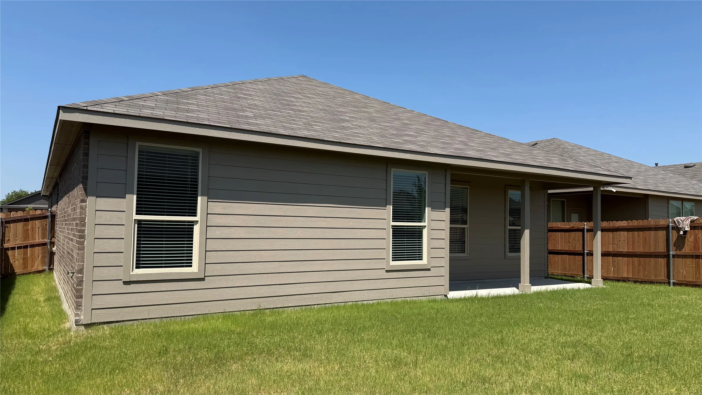 Rear exterior featuring a covered patio, shingle roofing, and horizontal siding