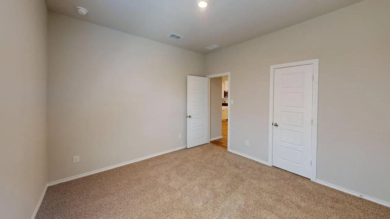 Carpeted room with neutral wall tones and white trim