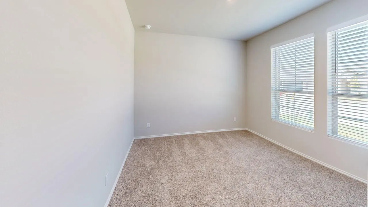 Light-filled room featuring neutral wall paint, two windows with horizontal blinds, and textured carpet flooring