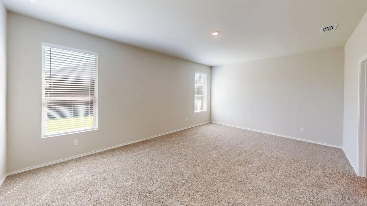 Spacious room featuring plush carpeting, two windows with blinds, recessed lighting, and a neutral wall palette