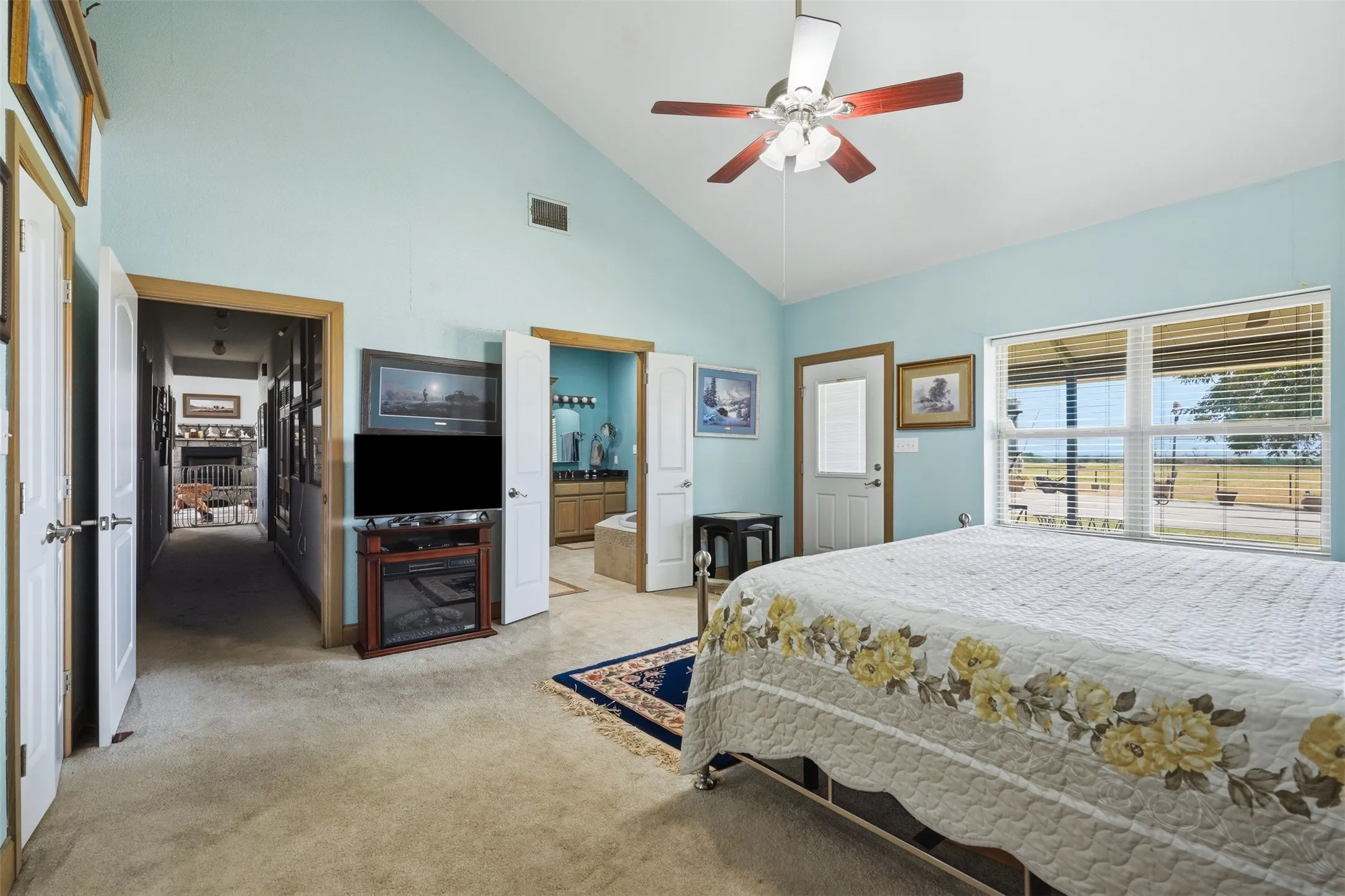 Naturally lit primary bedroom also features exit onto the backyard patio