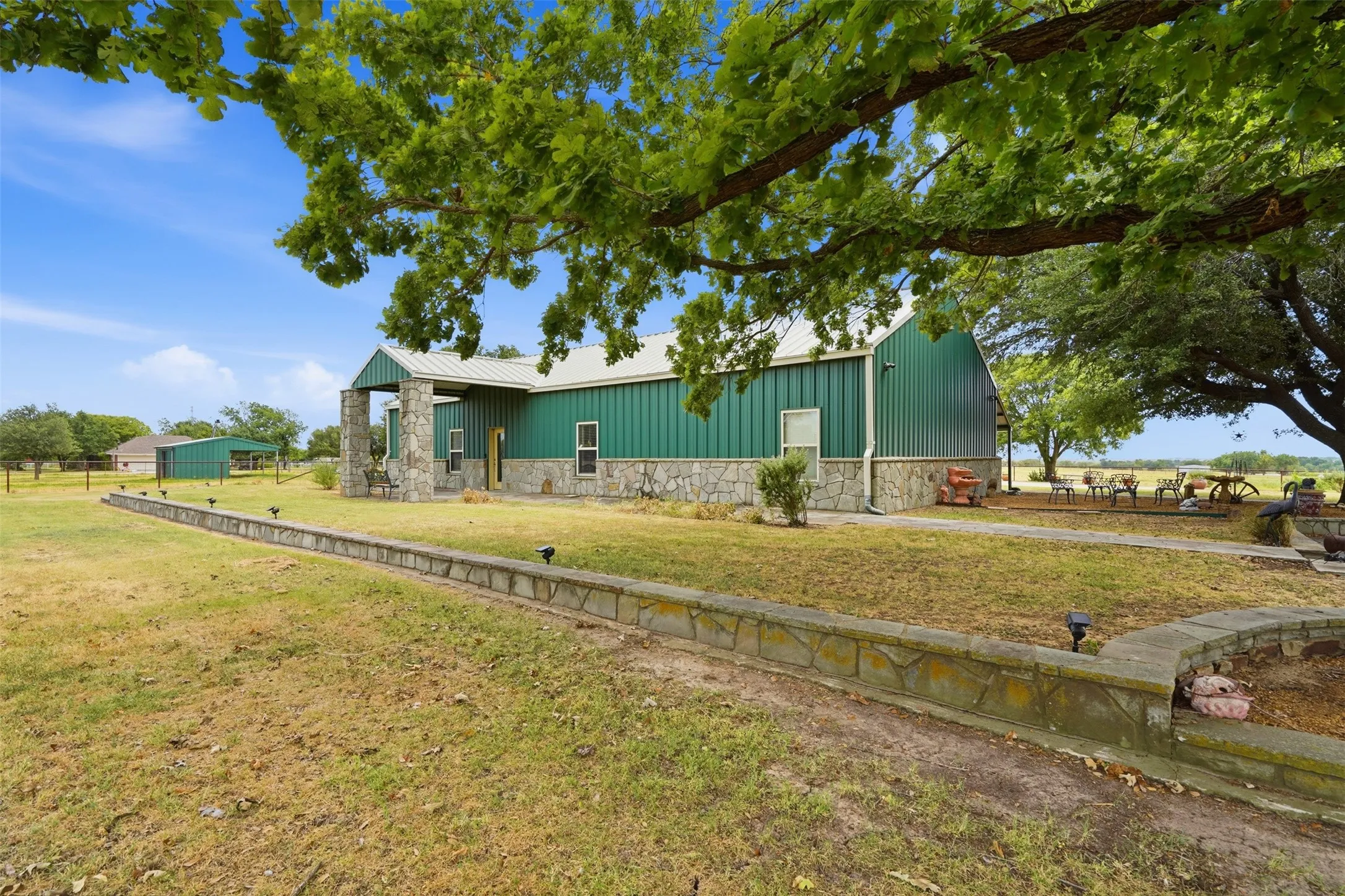 Front of home with established shade trees and front yard with lots of landscaping opportunity