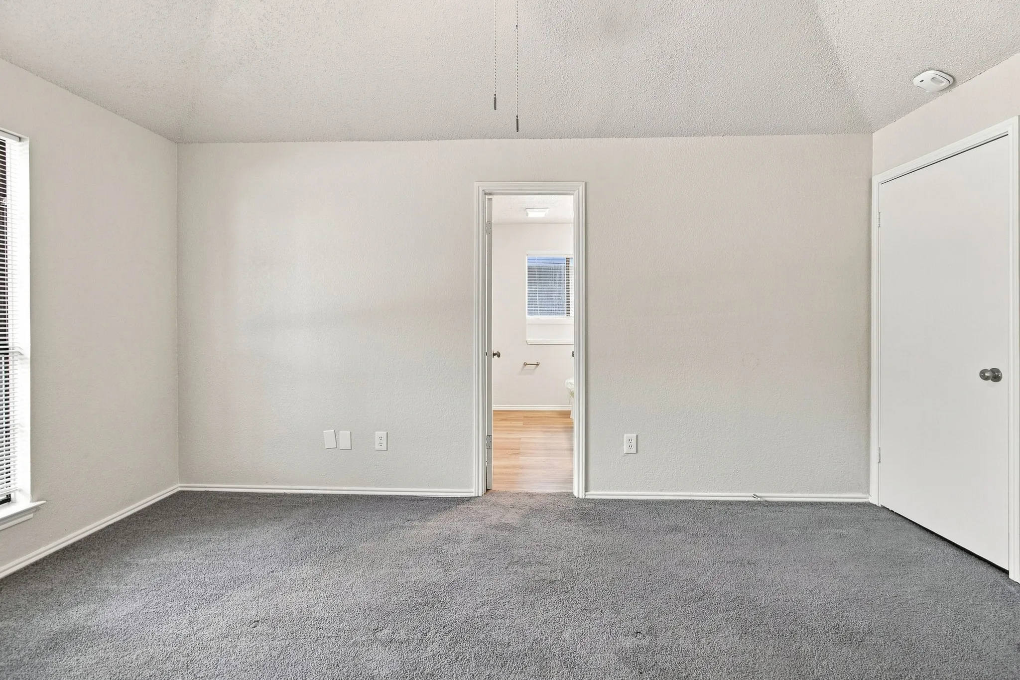 Bedroom featuring gray carpeting, light-colored walls, and white trim