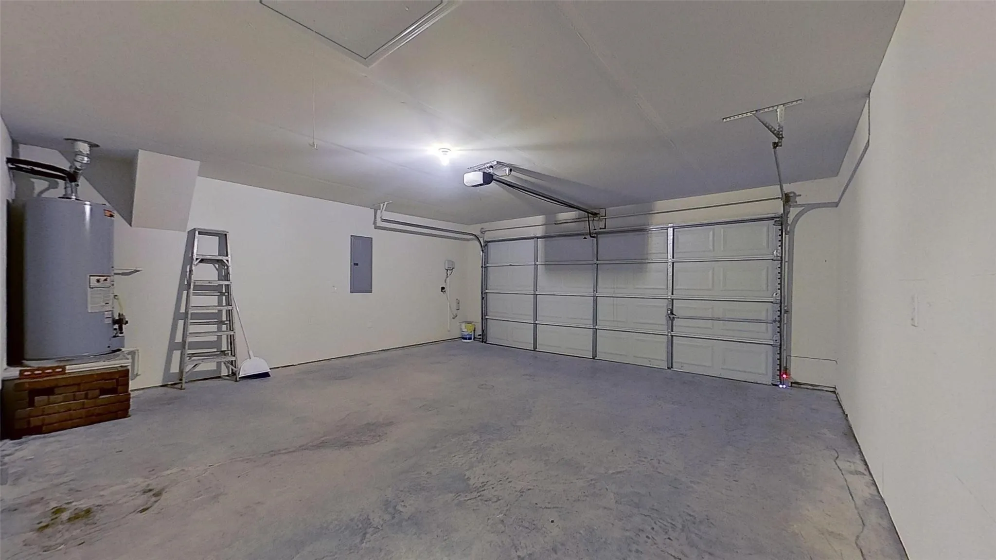 Spacious garage featuring a concrete floor, painted walls, and a paneled garage door