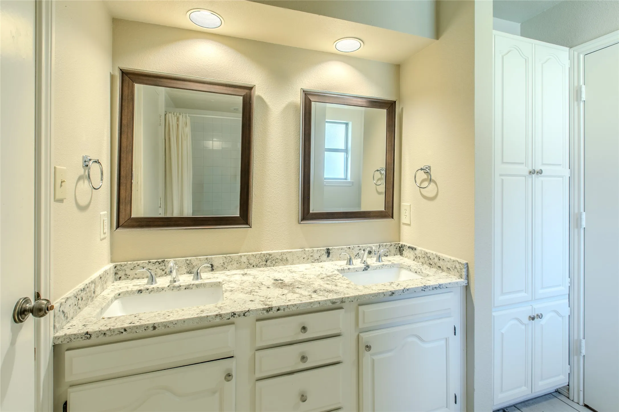 Dual vanity with integrated sinks and a light-toned speckled countertop
