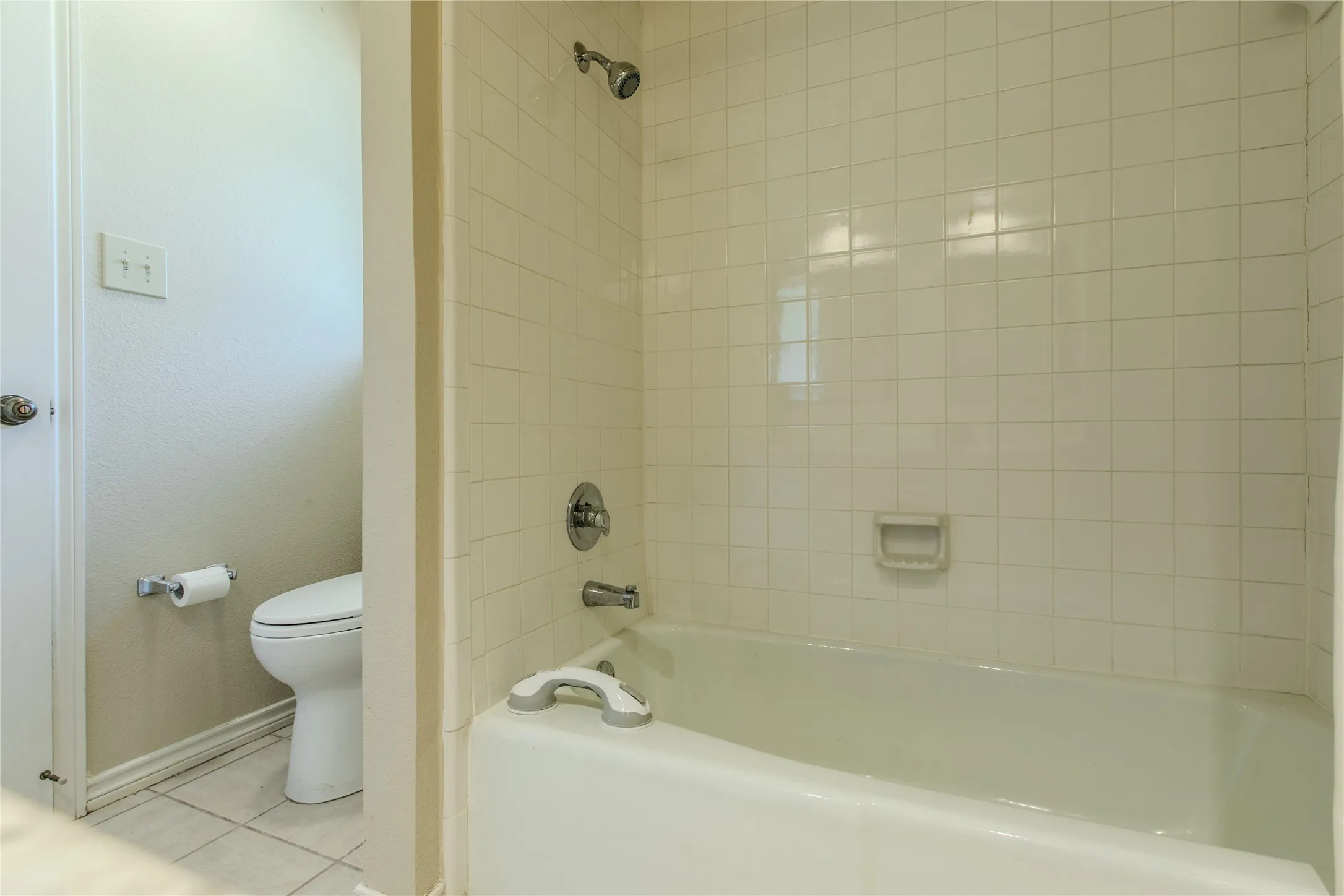 Full Bathroom with ceramic tile surround, alcove bathtub with shower combination, chrome fixtures, and ceramic tile flooring