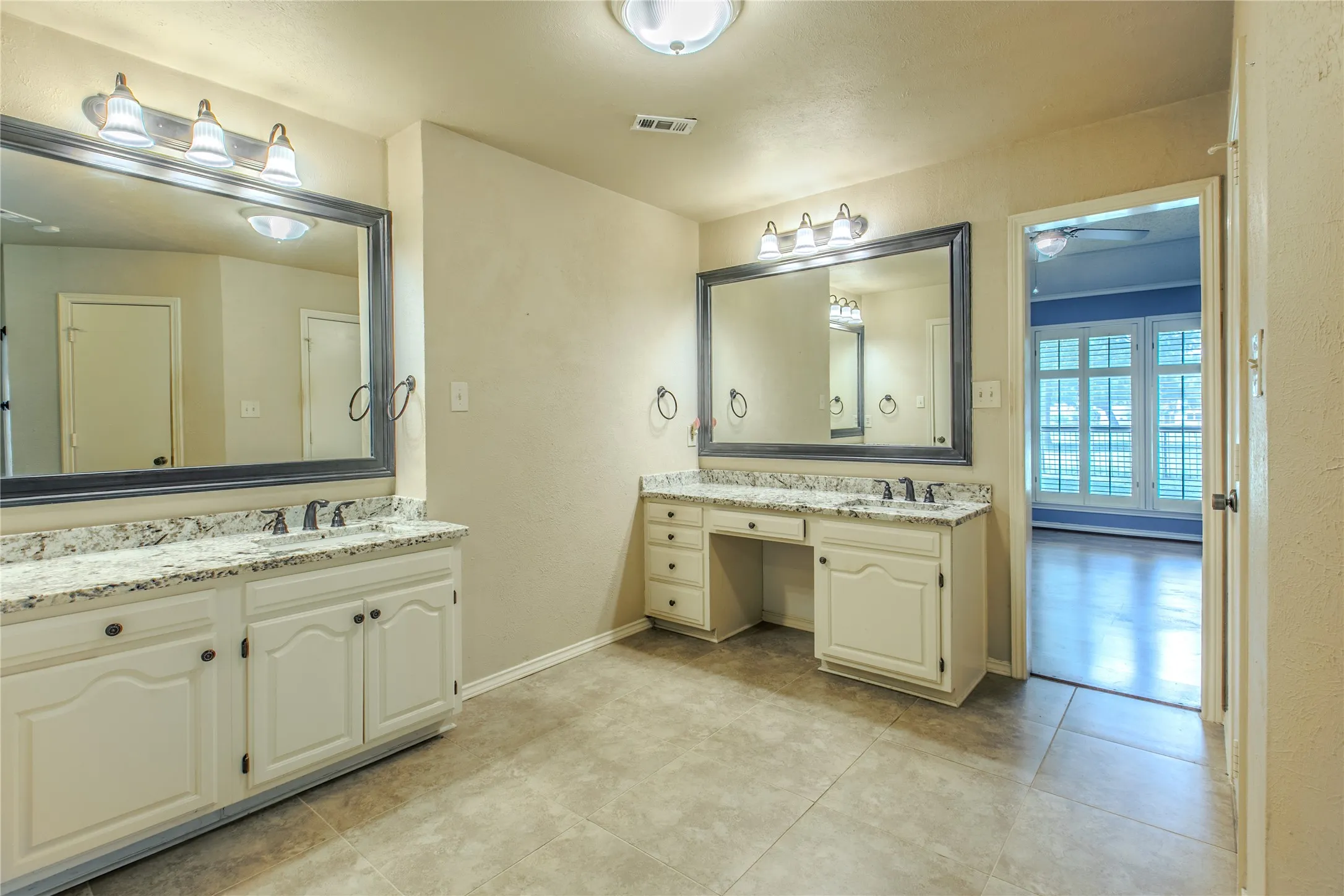 Dual vanity setup featuring white cabinetry and light-toned countertops