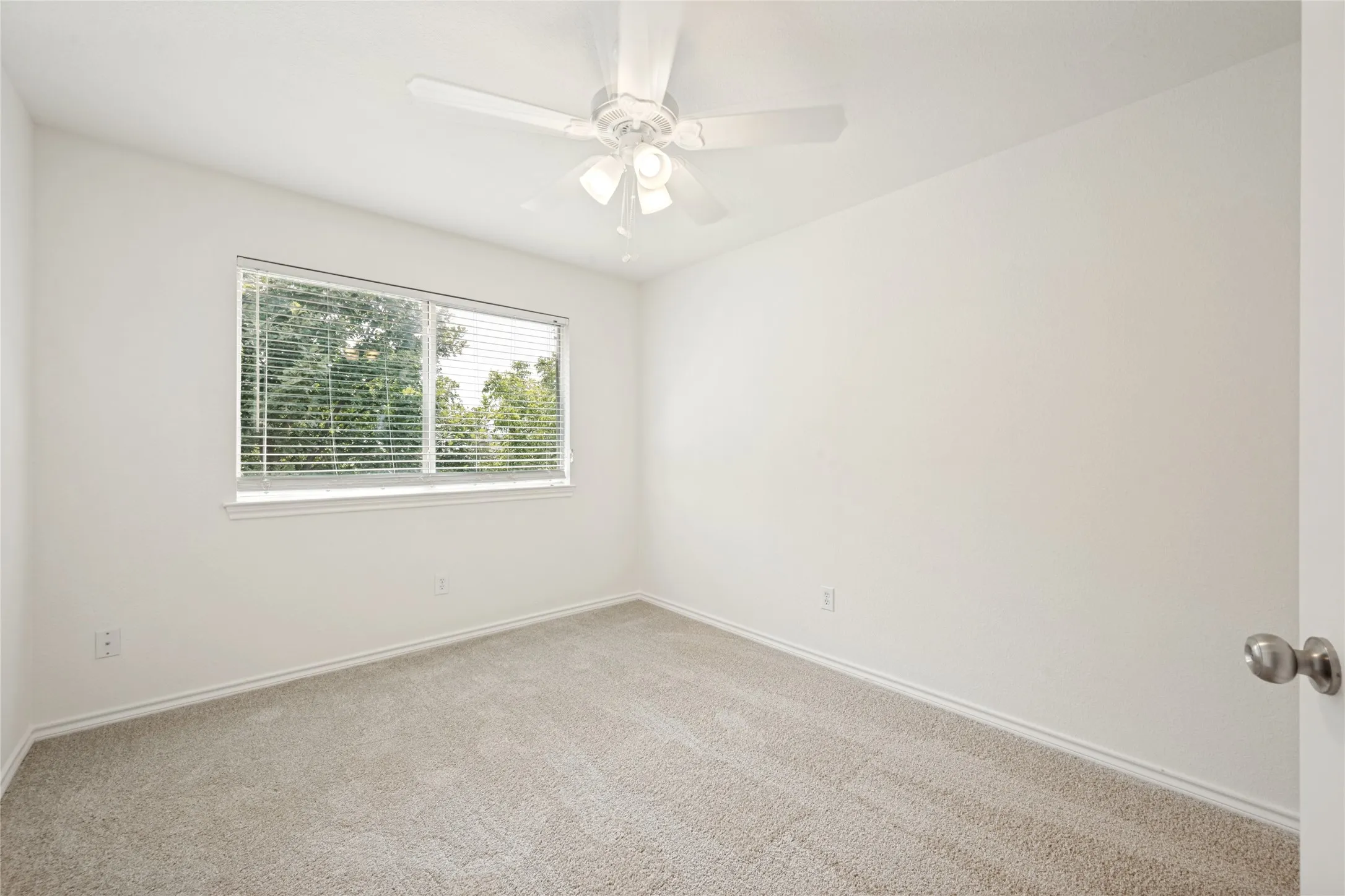 Neutral-toned carpeting and white walls create a bright ambiance