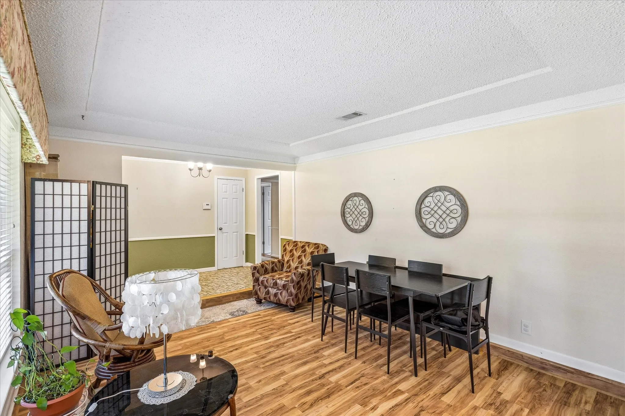 Open concept living area featuring wood-finish flooring and crown molding