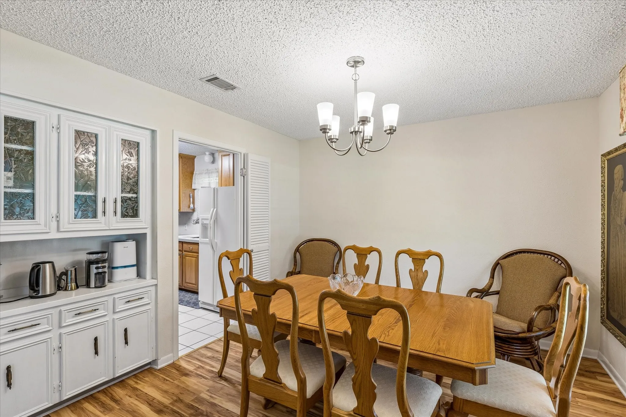 Elegant dining room featuring a wood-finish dining table with Queen Anne-style chairs, hardwood flooring, and a coordinating upholstered armchair