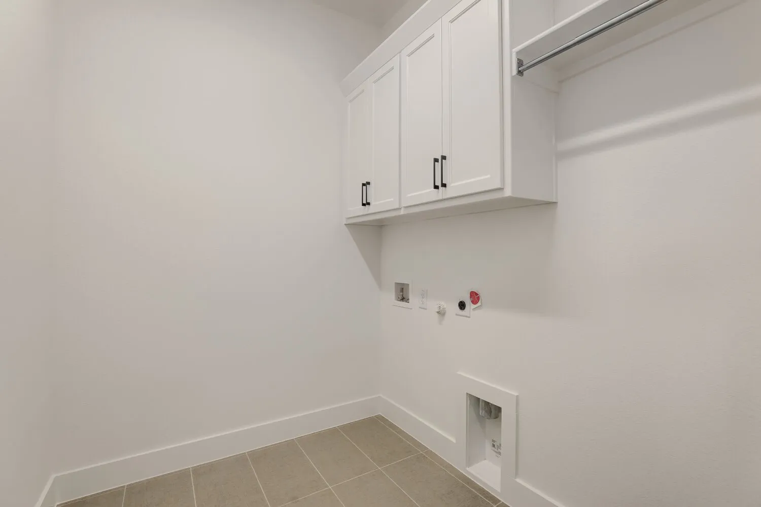 White shaker cabinetry with matte black hardware, built-in shelving, and tile flooring