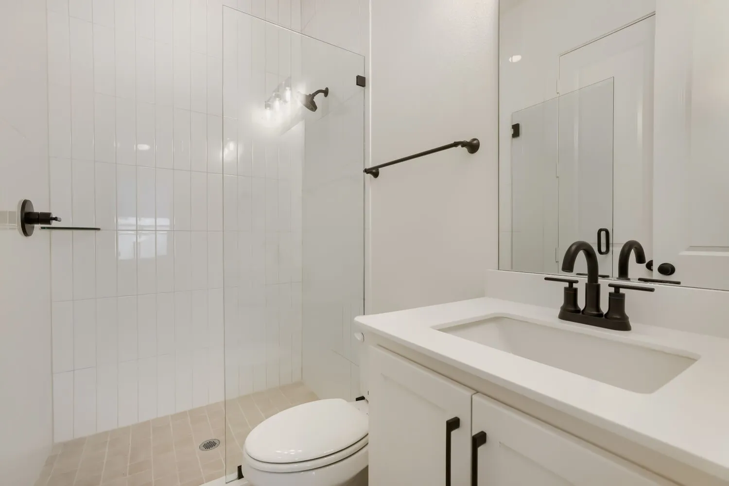 White vanity with an integrated sink, matte black faucet, and white countertop