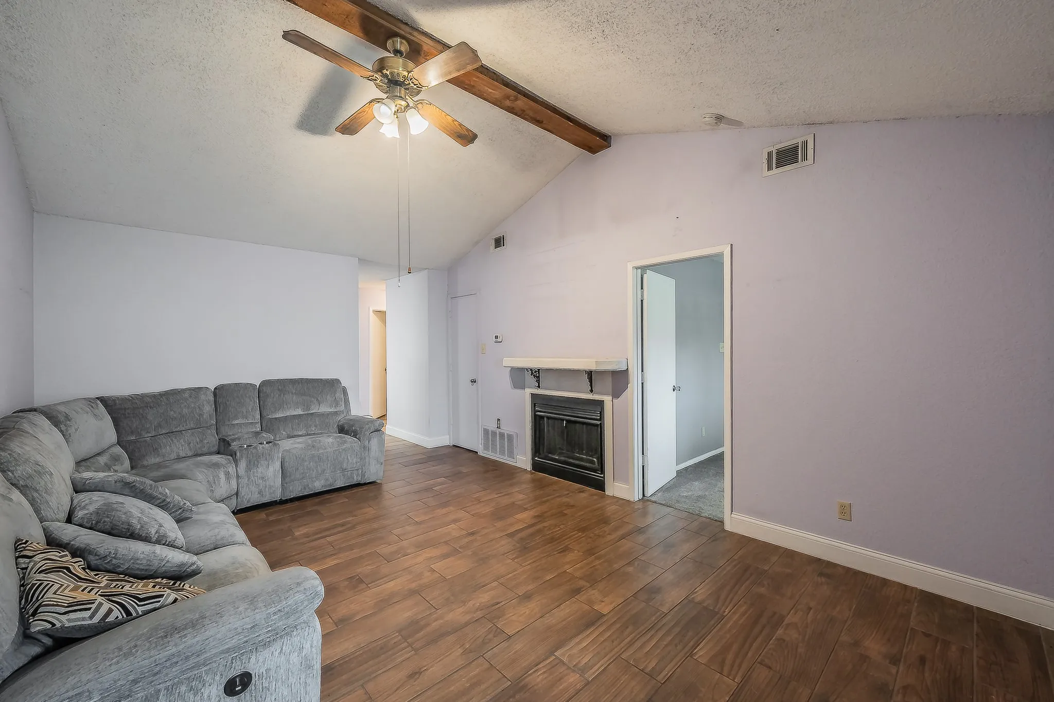 Vaulted ceiling with exposed wood beam and ceiling fan