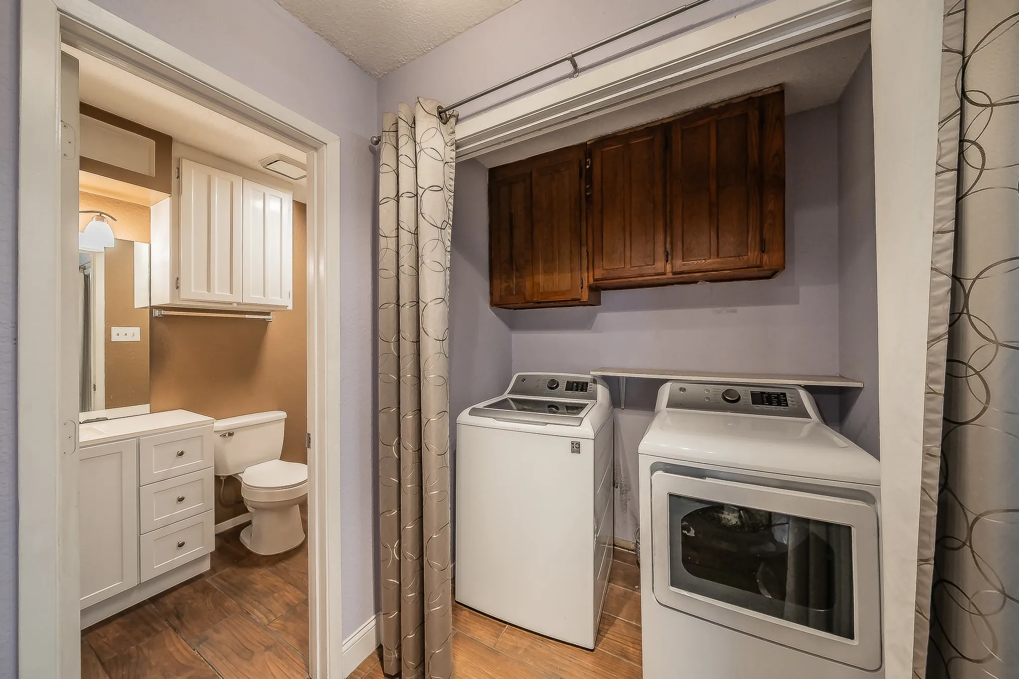 Dedicated laundry area with wood-finish flooring