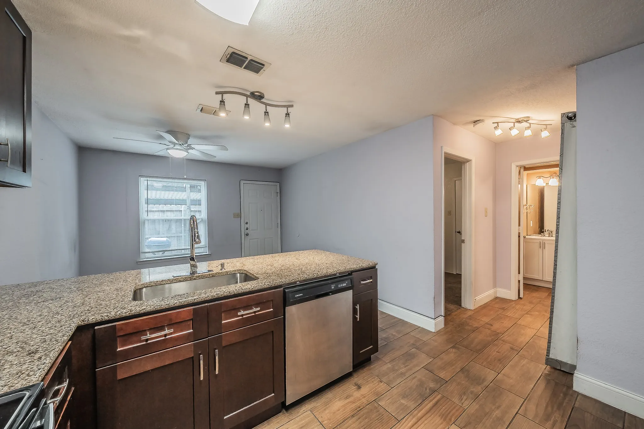 Kitchen island with granite-style countertop and integrated stainless steel sink