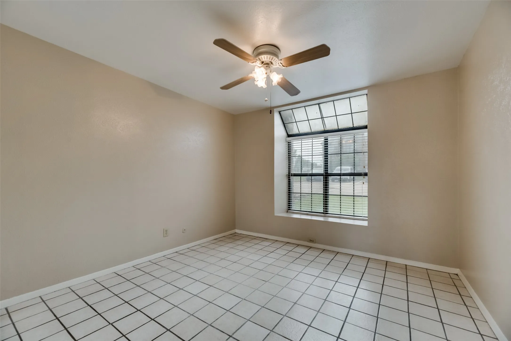 Tiled empty room featuring ceiling fan