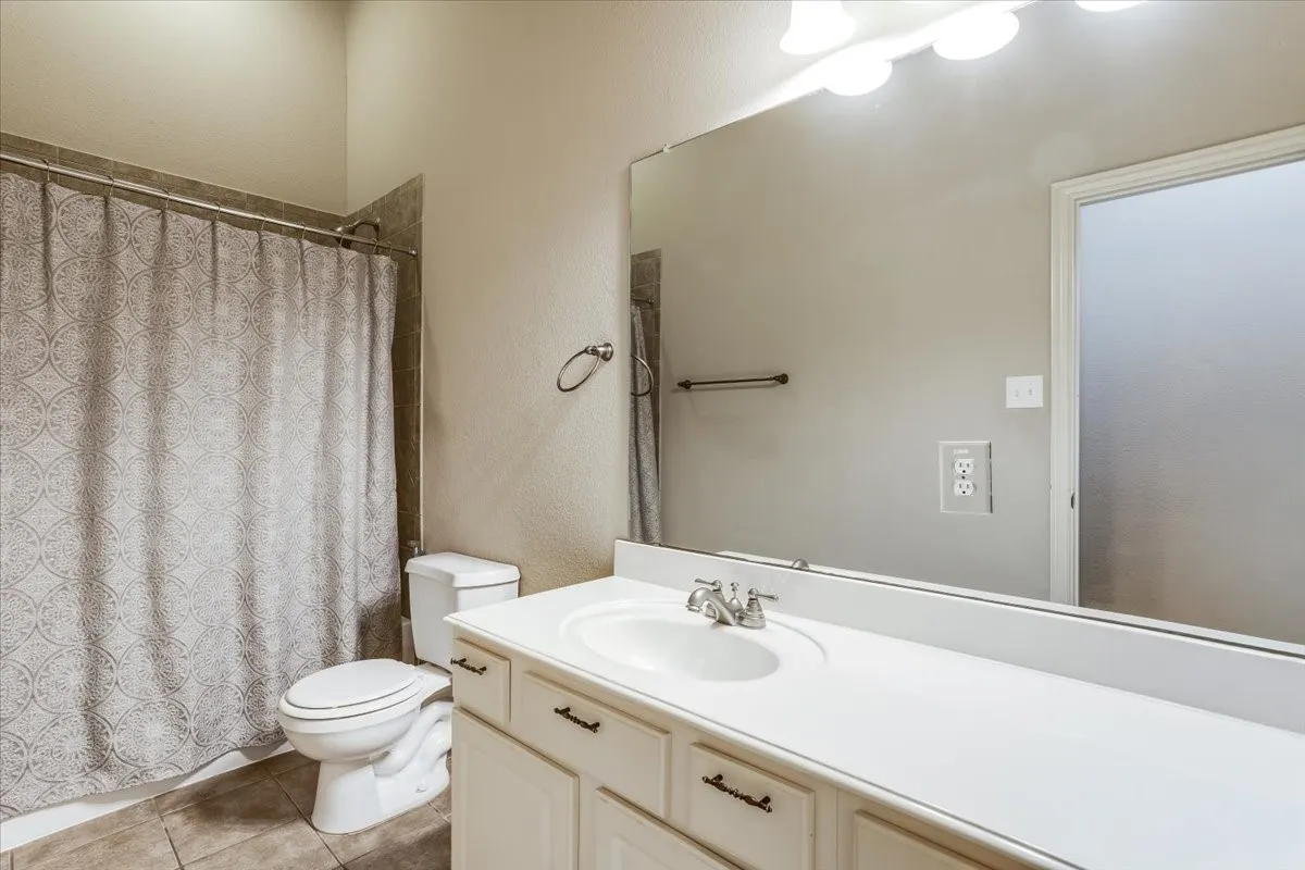 Vanity with integrated sink, chrome faucet, and white cabinetry with dark hardware
