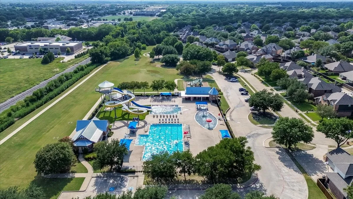 Community aquatic center featuring multiple swimming pools, water slides, a splash pad, and dedicated pool buildings