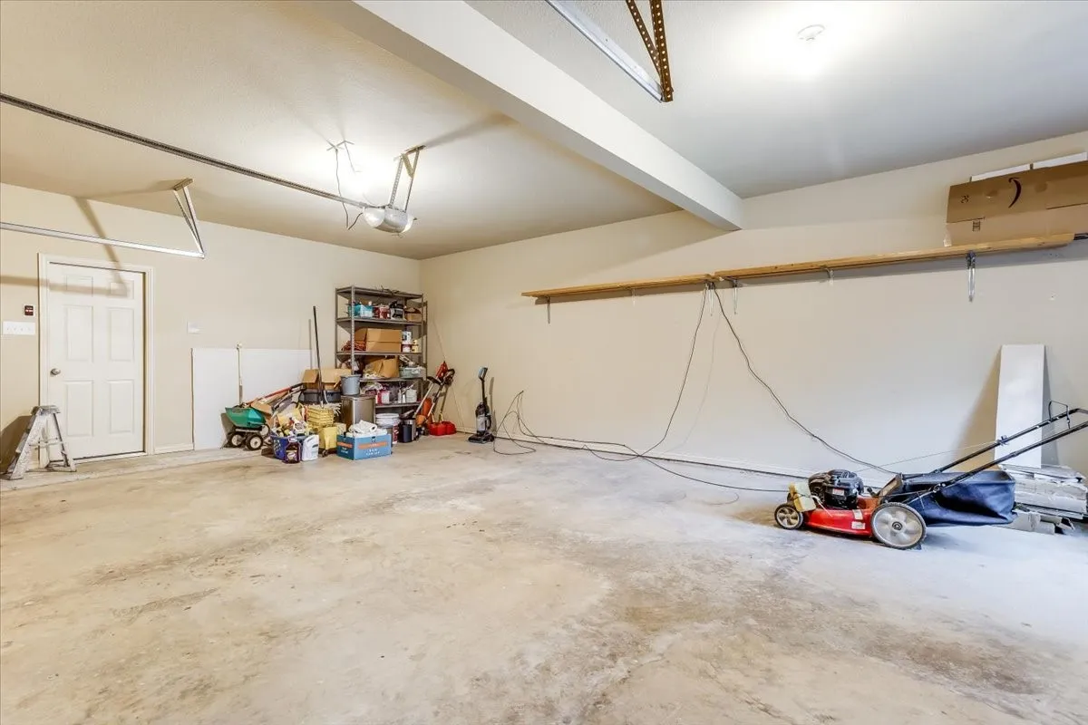 Spacious garage featuring concrete flooring, an overhead garage door track system, and an interior access door