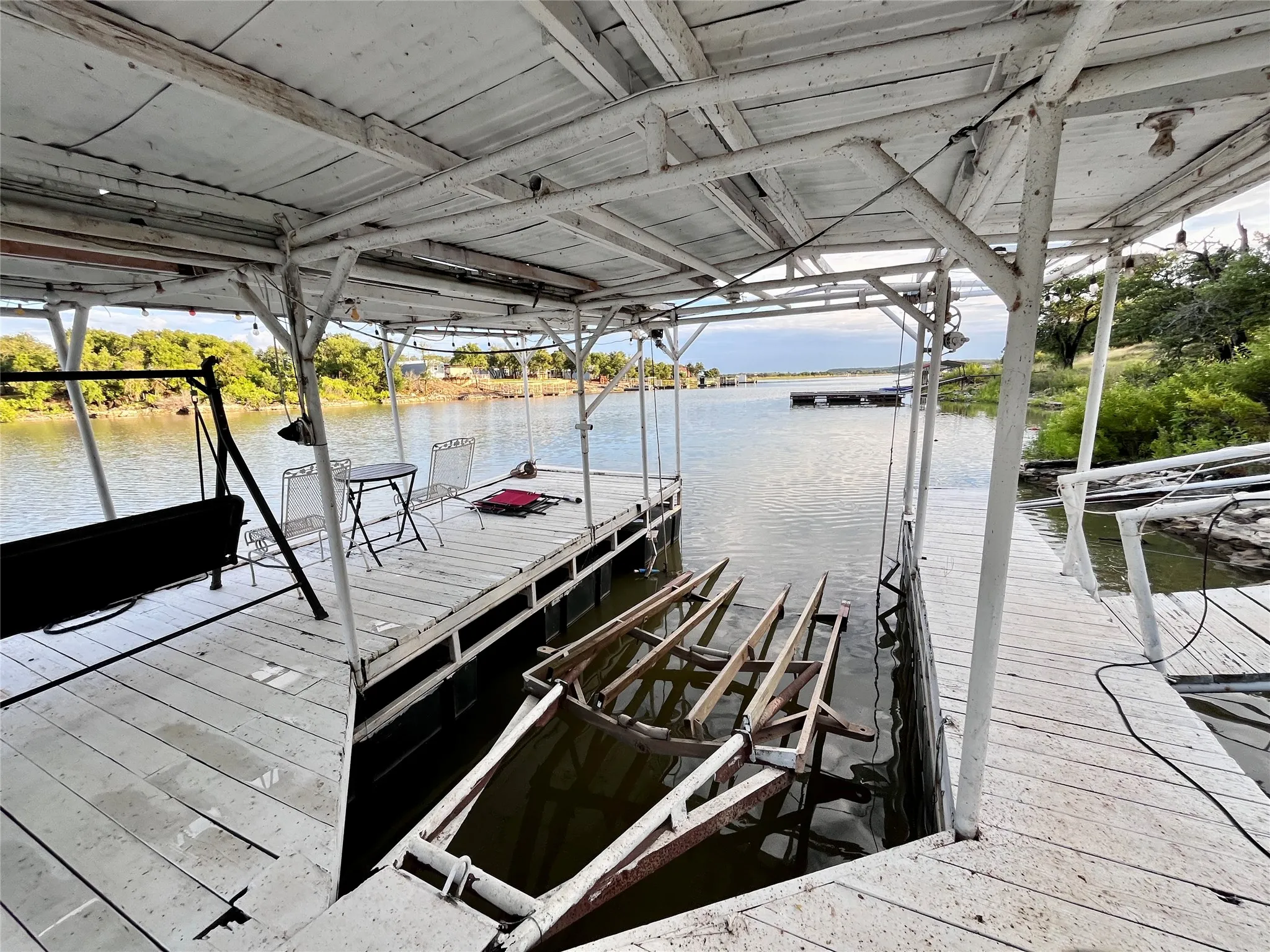 Private covered boat dock with multiple slips, seating areas, and easy lake access.