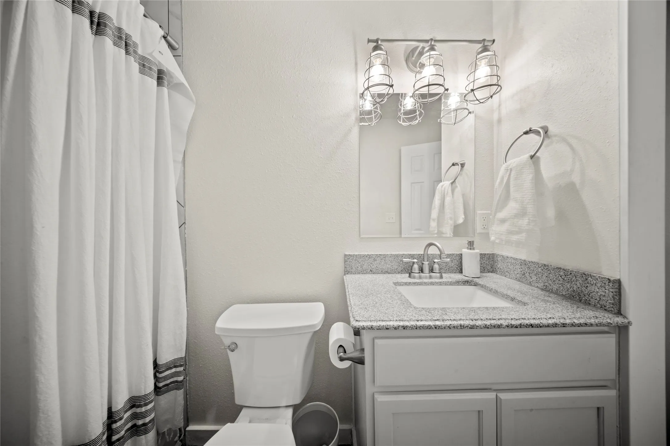 Bathroom vanity featuring a light-toned countertop, integrated sink, and brushed nickel faucet