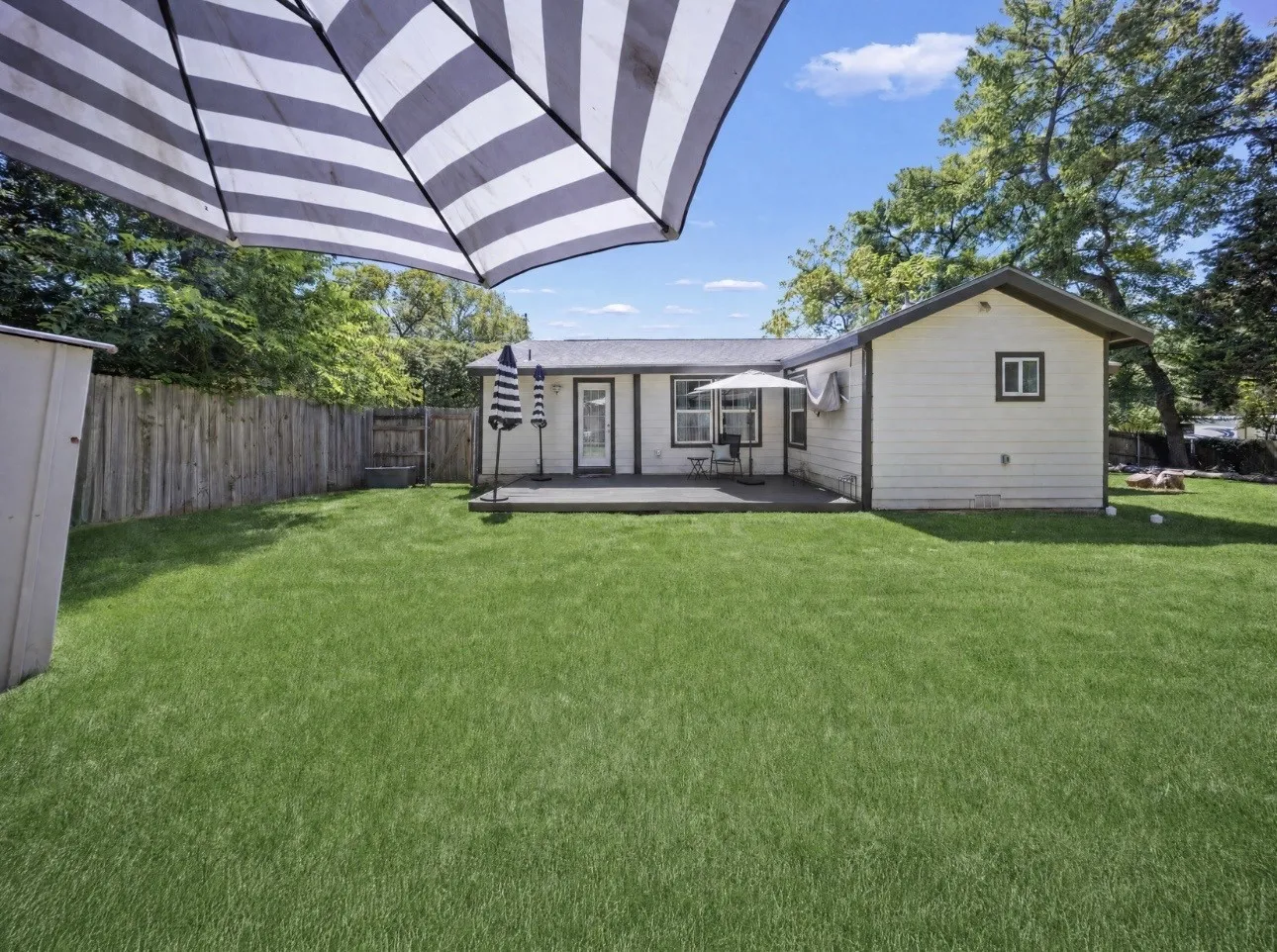 Expansive lawn area featuring a wooden privacy fence