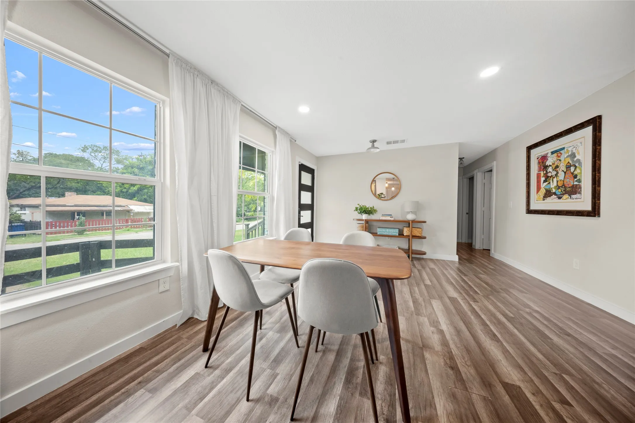 Spacious interior featuring wood-finish flooring, recessed lighting, and large windows with white trim
