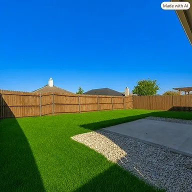 Expansive backyard featuring a manicured lawn, full wood privacy fencing, a concrete patio, and a decorative gravel border