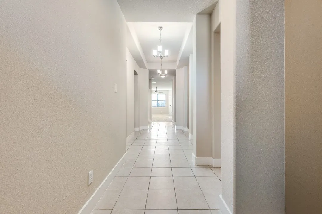 Hallway featuring light-toned walls, tile flooring, and recessed ceiling lighting