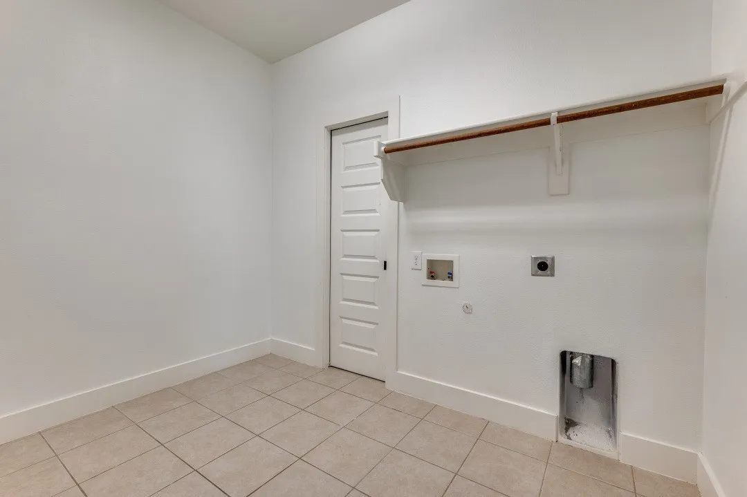 Ceramic tile flooring, white walls, built-in shelving, and a hanging rod